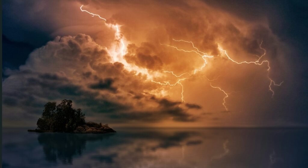 thunder lightning in the sky above the sea with a small island in evening time
