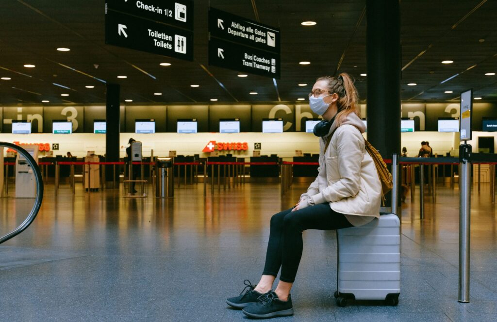 girl sitting on a suitcase in airport